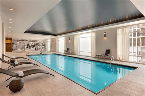 An Indoor Swimming Pool With Lounge Chairs Around It