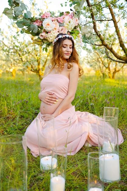 정원에서 젊은 임산부 임신 여자의 아름 다운 배꼽 프리미엄 사진