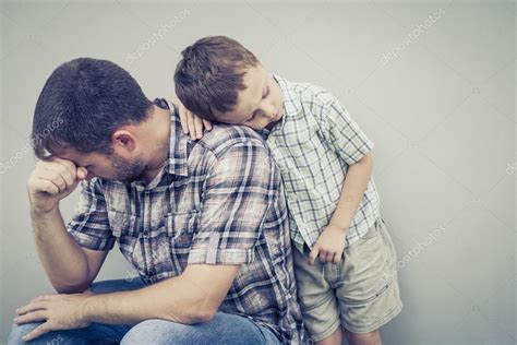 Sad Son Hugging His Dad Near Wall — Stock Photo © Altanaka 86889236