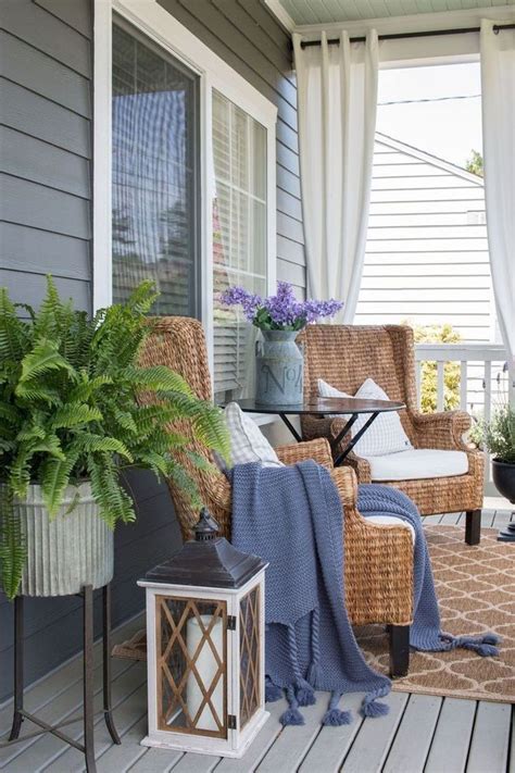 A Porch With Wicker Chairs And Potted Plants On The Front Porch