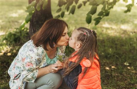 Joven Madre Besa A Su Hija En El Parque En Verano Concepto De Familia