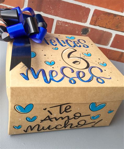 A T Box With A Blue Bow On Top That Says Elegs E Meos