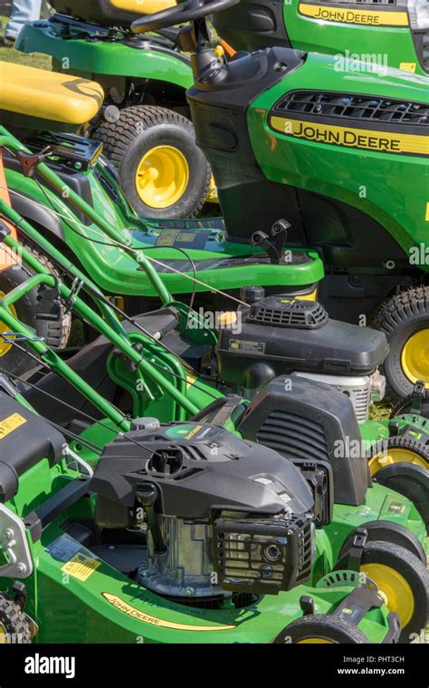 A Selection Of Green John Deere Lawn Mowers And Petrol Ride On Mowers