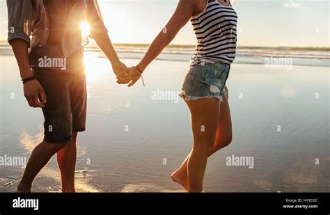 Cropped Shot Of Young Couple Holding Hands And Walking On The Beach