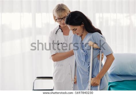 Doctor Helping Female Patient Crutches Hospital Stock Photo 1697840230