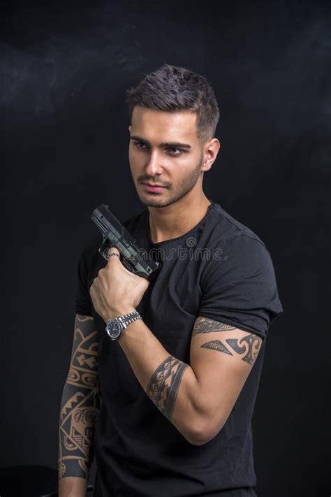 Молодой человек держа оружие руки Стоковое Фото изображение насчитывающей модель молодо