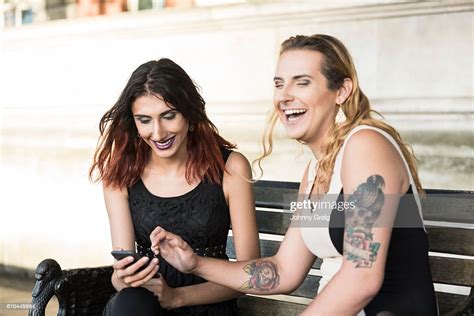 Two Transgender Female Friends Laughing With Cell Phone High Res Stock