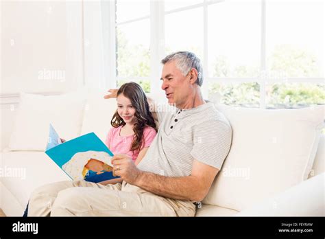 Smiling Grandfather And Granddaughter Reading Book Stock Photo Alamy