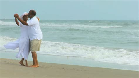 Close Up Elderly African American Couple Smiling Dancing On Beach Stock