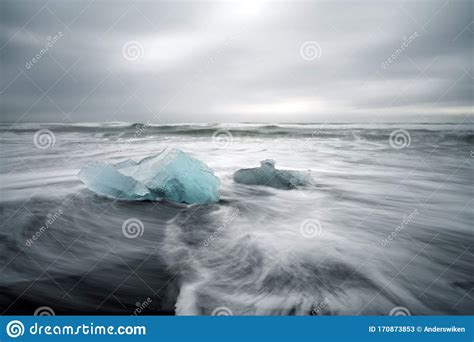 Crystal Clear And Blue Ice Chunks Washes Up On The Black