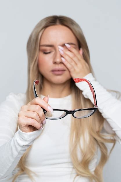 Premium Photo Portrait Of Woman Holding Her Glasses While Rubbing Her