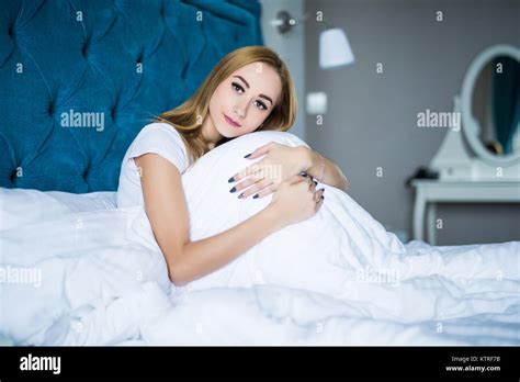 Sad Brunette Lying On Bed Hugging Her Knees At Home In The Bedroom Stock Photo Alamy