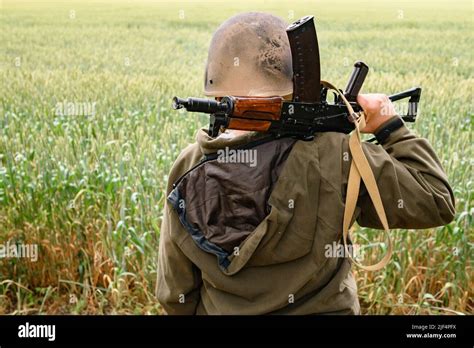 A Soldier With A Machine Gun Stands In A Field Ukrainian Wheat Fields