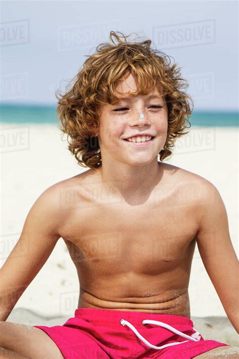 Spain Boy Sitting On Beach Smiling Stock Photo Dissolve