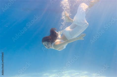 Woman In A White Dress Underwater In Swimming Pool Stock Photo And
