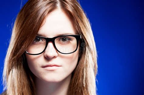 Strict Young Woman Adjusting Her Eyeglasses And Pointing Stock Image