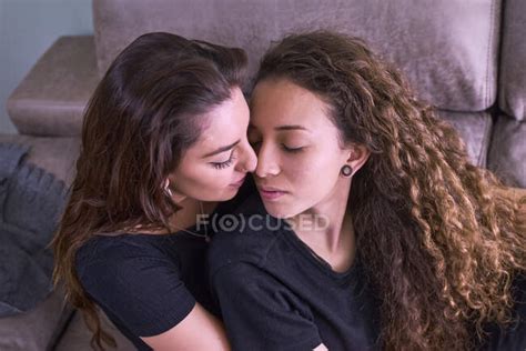 Vere Lesbiche Che Si Baciano Sul Divano A Casa Femmina Famiglia Stock Photo