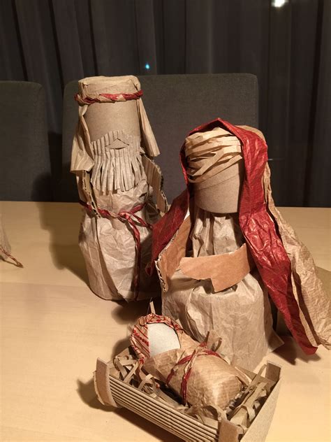 Two Paper Mache Dolls Sitting On Top Of A Wooden Table