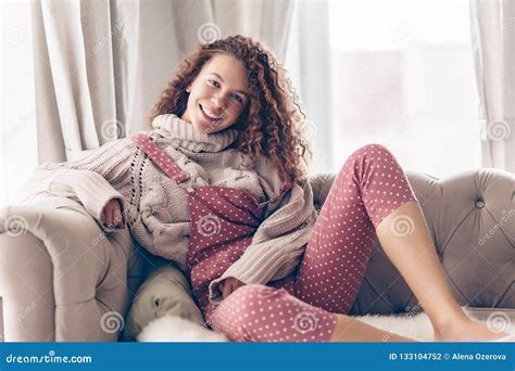 Девочка подросток в свитере и комбинезоне на кресле Стоковое Фото изображение насчитывающей