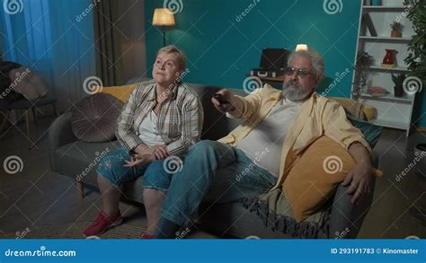 An Elderly Couple Is Watching Something On Tv Movie Or Program The Woman Is Unhappy Asking To