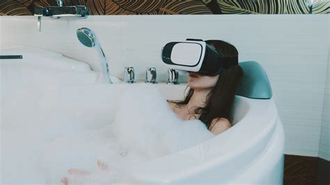 chica relajarse en el baño lleno de espuma en el baño con gafas de realidad virtual en la cabeza