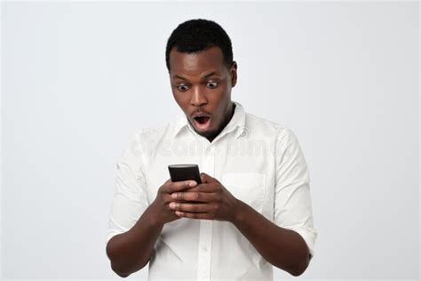 Homme Africain Regardant Le Téléphone Voyant Des Nouvelles Choquantes Ou Des Photos Avec émotion