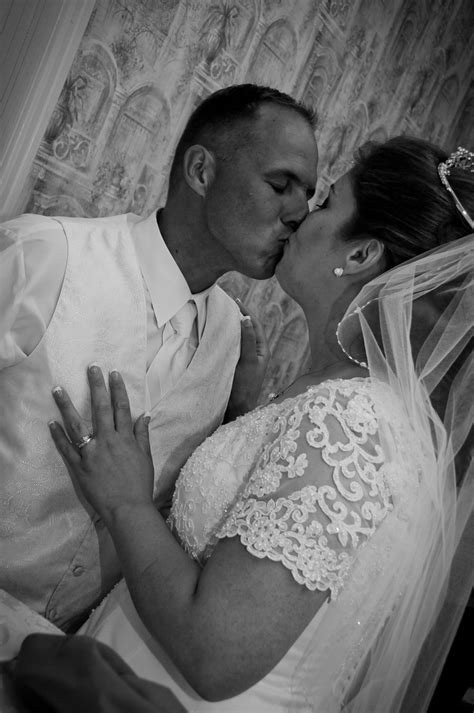 A Bride And Groom Kissing On Their Wedding Day