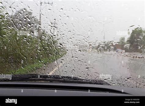 Road View Through Car Windshield With Rain Drops Driving In Rain Stock