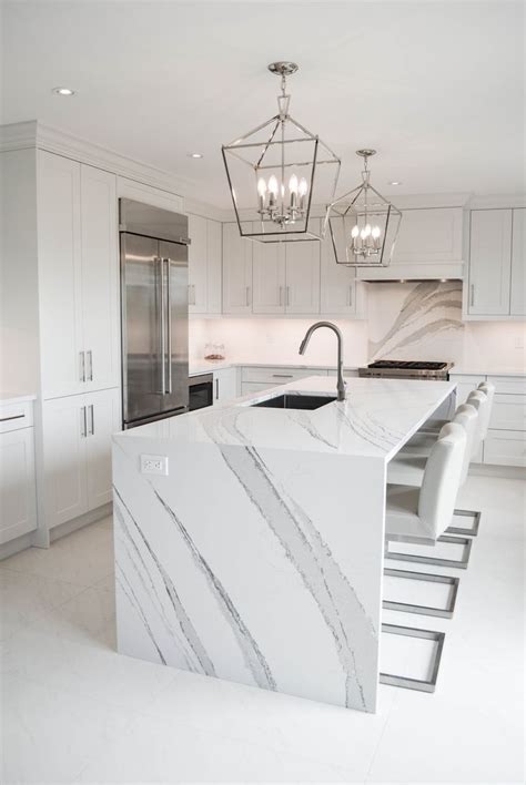 A Large Kitchen With Marble Counter Tops And White Cabinetry Along