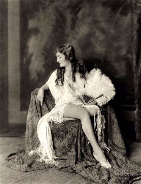 An Old Fashion Photo Of A Woman Sitting On A Chair With Feathers In Her