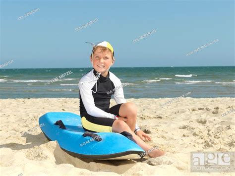 Portrait Of Boy Nipper Child Surf Life Savers On Surfboard At Beach