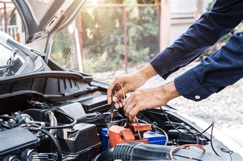 Technician Auto Mechanic Using A Power Meter To Check The Car Batter