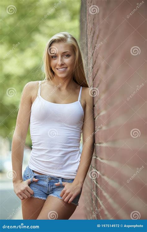 Beautiful Blonde Woman In White Tanktop And Denim Shorts Stock Photo
