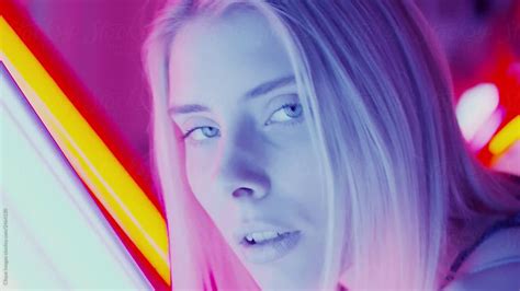 Sensual Woman Licking Her Lips In Neon Lights By Stocksy Contributor