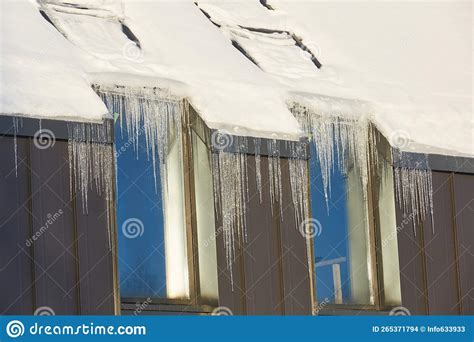 Icicles On Roof Of Modern House In Sunny Winter Day Formation Of