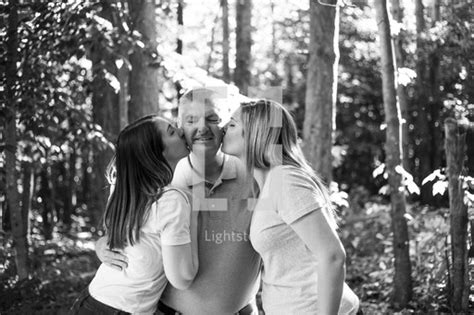 Daughters Kissing Dad On The Cheeks — Photo — Lightstock