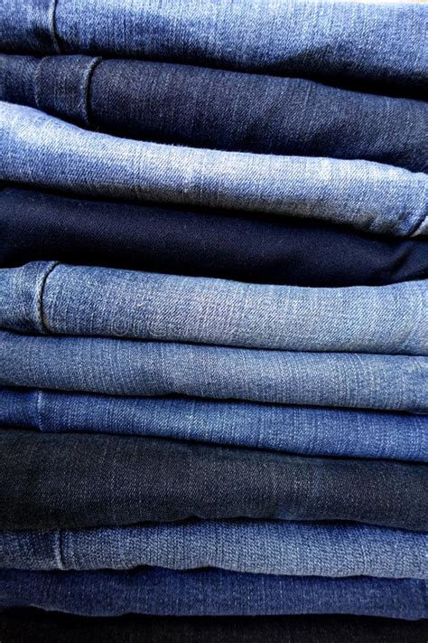 Pile Of Folded Blue Denim Jeans Closeup In A Variety Of Shades Stock