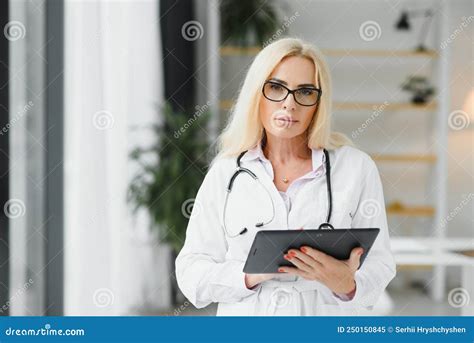 Female Doctor Wearing Lab Coat And Stethoscope And Holding Clipboard In