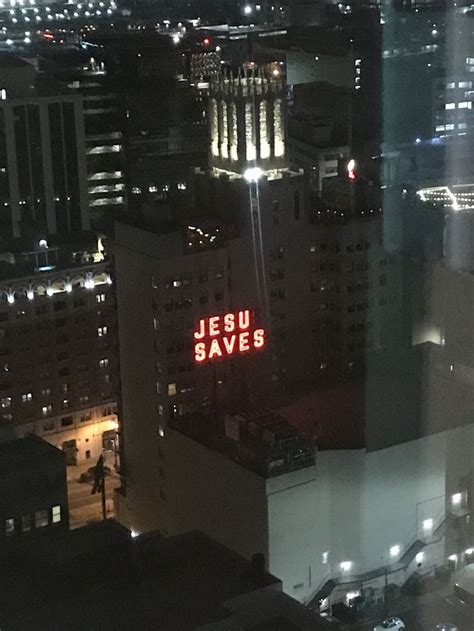 An Aerial View Of A City At Night With The Word Jesus Saves Written On It