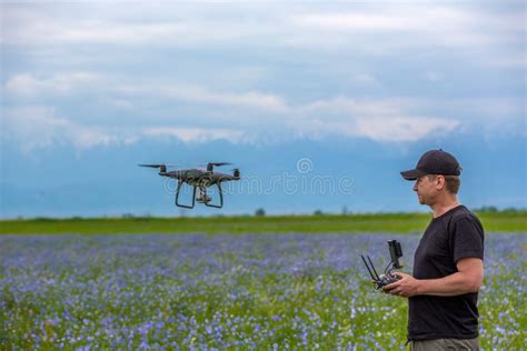 Man Operating Of Flying Drone Quadrocopter At The Green Field Stock