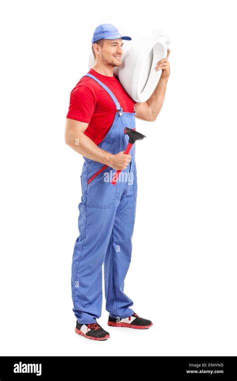 Full Length Portrait Of A Male Plumber Carrying A Toilet And Holding A