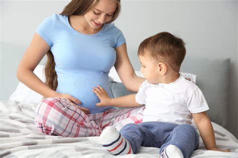 Mujer Embarazada Joven Con Su Pequeño Hijo Lindo En Casa Imagen De