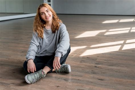 Free Photo Smiling Portrait Of A Young Woman Relaxing On Hardwood