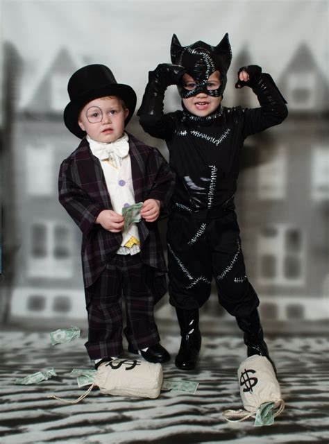 Kleines Mädchen In Catwoman Kostüm Und Junge Im Pinguin Kostüm Cat