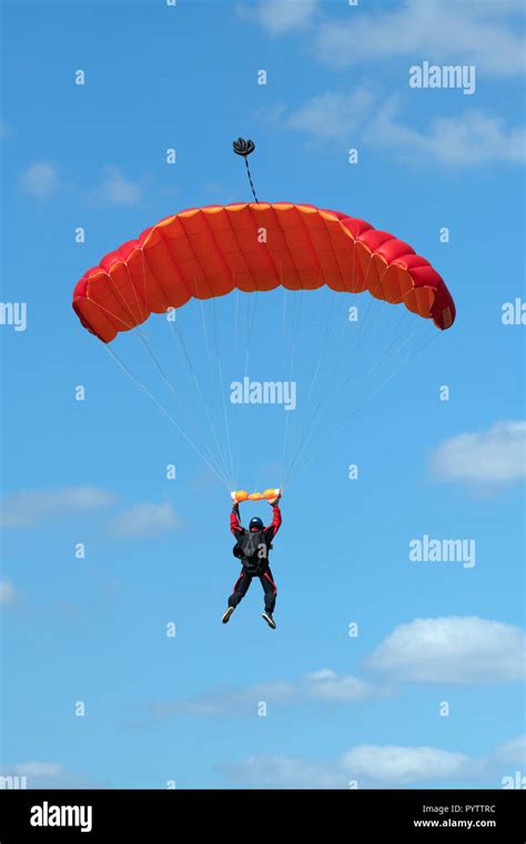 Parachutist Floating To A Red Square Shaped Parachute Stock Photo Alamy
