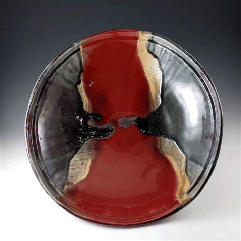 A Red And Black Plate Sitting On Top Of A White Table
