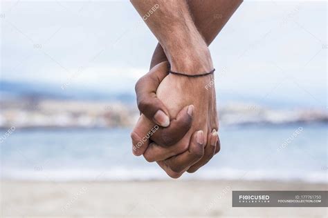 Close Up Of Two Hands Connected On The Beach — Water Trust Stock