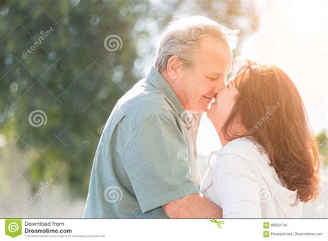 Middle Aged Couple Enjoy A Romantic Slow Dance And Kiss Outside Stock
