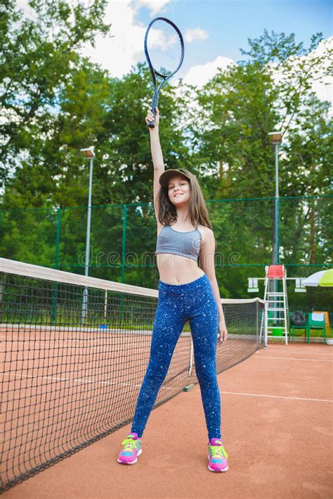 Милая девушка играя теннис и представляя в суде внешнем Стоковое Фото изображение