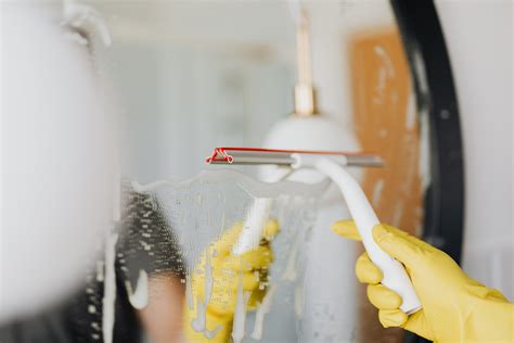 Faceless Person Removing Water From Mirror · Free Stock Photo